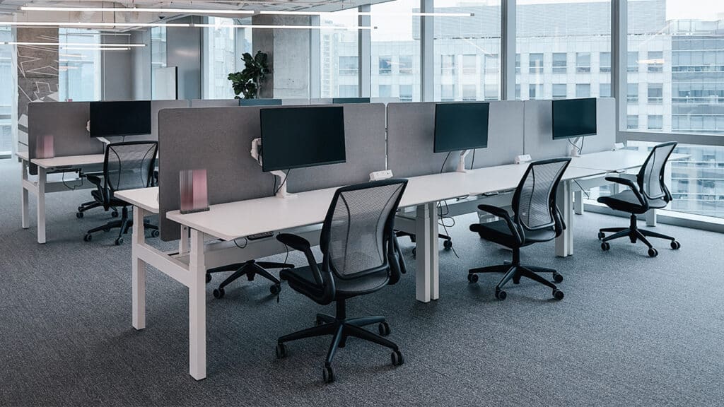 Modern white-label customer service office by NEARSOL featuring ergonomic workstations, sleek monitors, and a collaborative open-space layout with natural lighting.