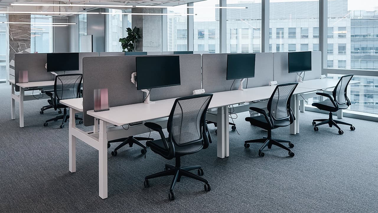 Modern white-label customer service office by NEARSOL featuring ergonomic workstations, sleek monitors, and a collaborative open-space layout with natural lighting.