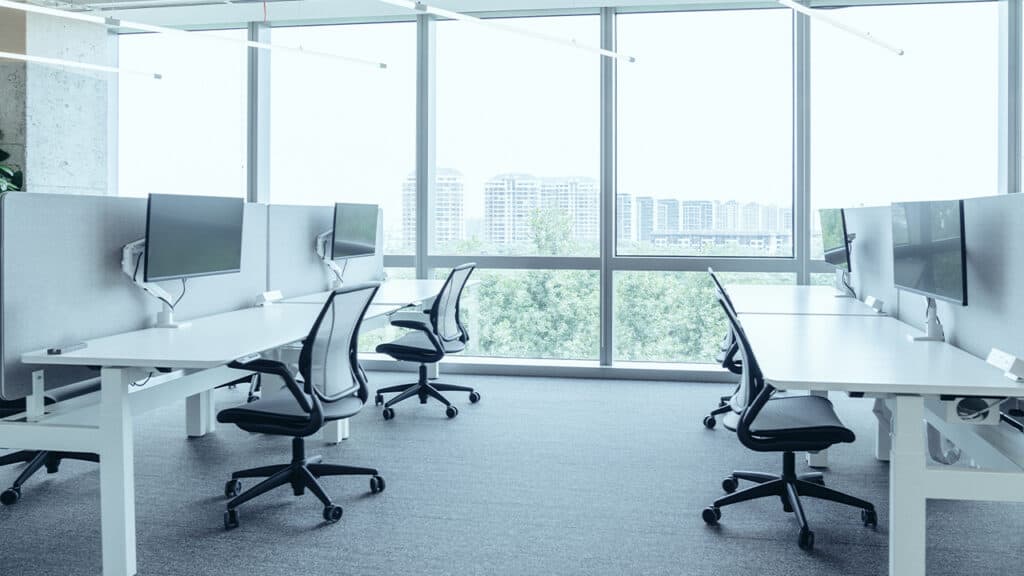 Bright and spacious NEARSOL office setup for white-label customer service teams, featuring minimalist workstations, ergonomic chairs, and large windows overlooking a city skyline.